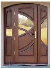 Brązowe, trójdzielne drzwi wejściowe z przeszkleniami o geometrycznym wzorze, z metalową klamką i widocznym fragmentem elewacji budynku w tle.