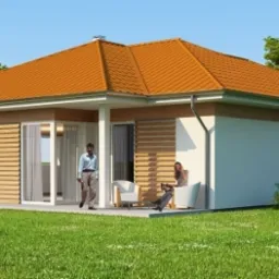 Parterowy dom z pomarańczowym dachem, drewnianymi żaluzjami i tarasem, na którym siedzi kobieta z laptopem i stoi mężczyzna, otoczony zielonym trawnikiem i drzewami.