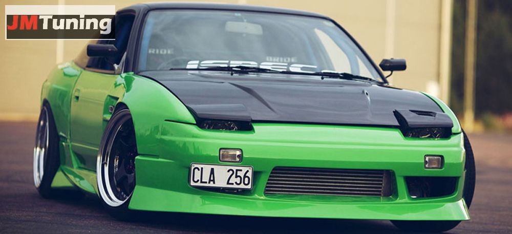 Zielony samochód sportowy z czarną maską i tablicą rejestracyjną CLA 256, po tuningu w Nowej Wsi. Widoczne zmodyfikowane felgi i obniżone zawieszenie.