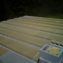 Wiązanie bloczków fundamentowych z poziomymi elementami konstrukcyjnymi, widoczne z góry, z elementami wentylacyjnymi w bloczkach.