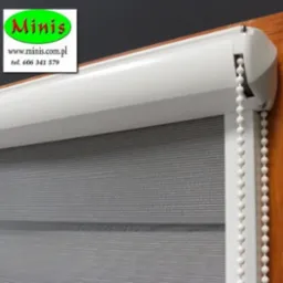 Szara przesłona okienna typu dzień i noc z białym mechanizmem i łańcuszkiem, widoczne logo producenta w lewym górnym rogu.