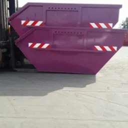 Dwa fioletowe kontenery metalowe z odblaskowymi pasami, jeden na drugim, podnoszone przez wózek widłowy w Gostycynie.