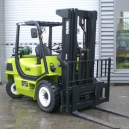 Wózek widłowy czołowy marki CLARK model CMP50sL zasilany LPG, prezentowany na zewnątrz na mokrej nawierzchni, z widoczną butlą gazową i metalową konstrukcją zabezpieczającą kabinę operatora.