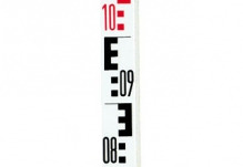 Fragment łaty niwelacyjnej z wyraźnie widoczną podziałką i cyframi 08, 09, 10 w kolorze czarnym i czerwonym na białym tle.