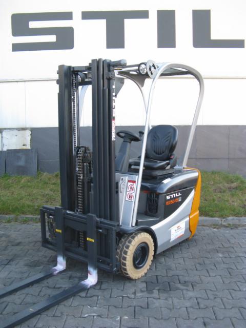 Nowy wózek widłowy STILL RX50-10 z czarną kabiną i srebrną konstrukcją, widoczny na tle szarej ściany z logo STILL. Jasne opony i czarne widły.