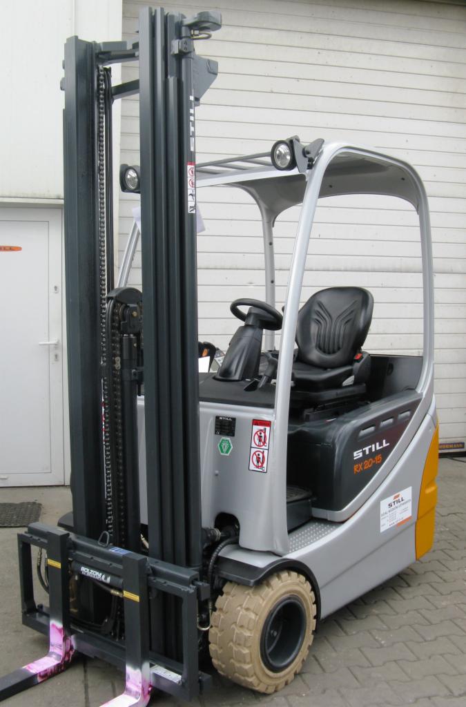 Elektryczny wózek widłowy STILL RX 20-15 w kolorze srebrnym z czarnym siedziskiem, widoczny z boku, na tle szarej ściany magazynu.