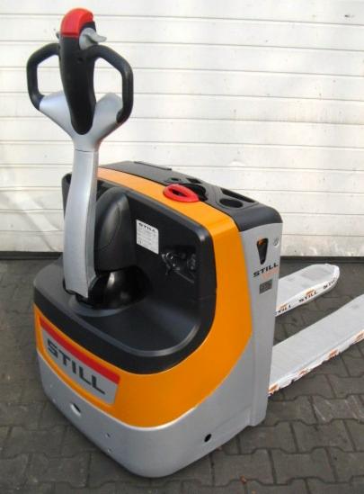 Elektryczny wózek paletowy STILL w kolorze pomarańczowo-szarym, z widłami zabezpieczonymi folią. Widoczna faktura kostki brukowej w tle.