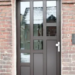 Brązowe wejściowe z szybami, osadzone w murze z czerwonej cegły, z widocznym odbiciem zaśnieżonego dachu w szybach.