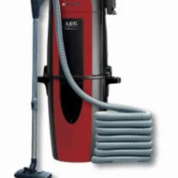 Zestaw do odkurzacza centralnego AEG: jednostka centralna w kolorze czarno-czerwonym, wąż i ssawka podłogowa. Widoczne logo AEG.