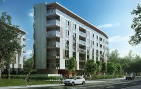 Wizualizacja nowoczesnego, wielopiętrowego budynku mieszkalnego z balkonami, z białym samochodem osobowym na pierwszym planie i zielenią drzew w tle.