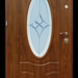 Brązowe drzwi zewnętrzne z owalnym przeszkleniem z delikatnym wzorem, widoczne zawiasy i klamka z rozetą.