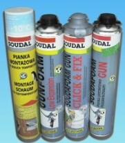 Cztery puszki pianki montażowej różnych typów i producentów, ustawione obok siebie na niebieskim tle. Widoczne napisy informacyjne na puszkach, w tym nazwy marek Soudal i Gunfoam oraz oznaczenia...