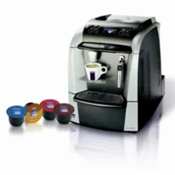 Automatyczny ekspres kapsułkowy Lavazza z filiżanką kawy i czterema kapsułkami różnych smaków na białym tle, prezentacja produktu.