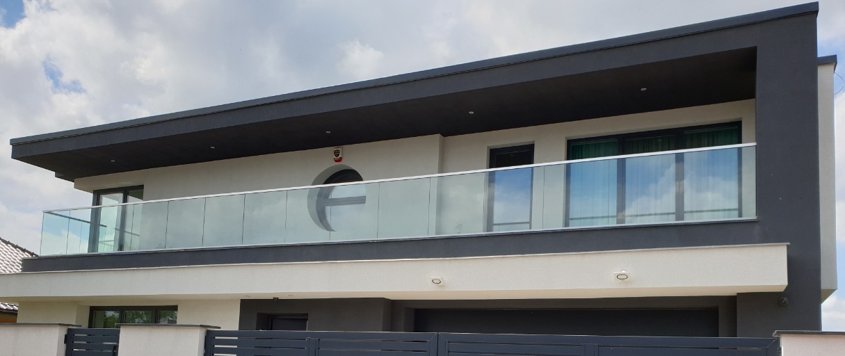 Nowoczesny dom z balkonem zabezpieczonym szkłem, okrągłe okno z logotypem firmy, Legnica.