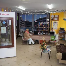 Ekspozycja okna z brązową ramą w biurze firmy Vetrex; w tle pracujące osoby, dekoracje świąteczne.