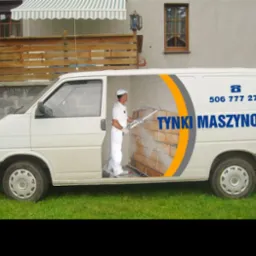 Reklama tynków maszynowych Dobieszowice na białym vanie z otwartymi drzwiami, gdzie widać pracownika w kombinezonie i maszynę do tynkowania.