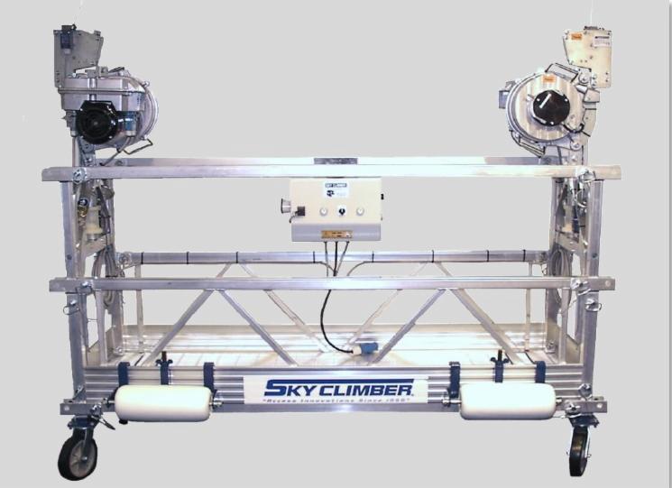 Aluminiowa platforma robocza zawieszona na linach z dwoma silnikami Sky Climber, widoczne kółka i panel sterowania.