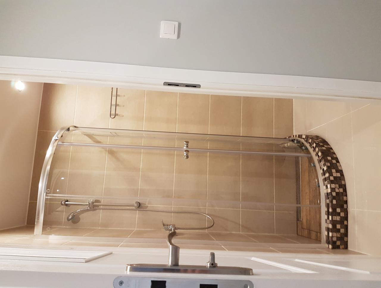 Zamontowana kabina prysznicowa z mozaiką na łuku w łazience w Krakowie, widok z dołu na armaturę.