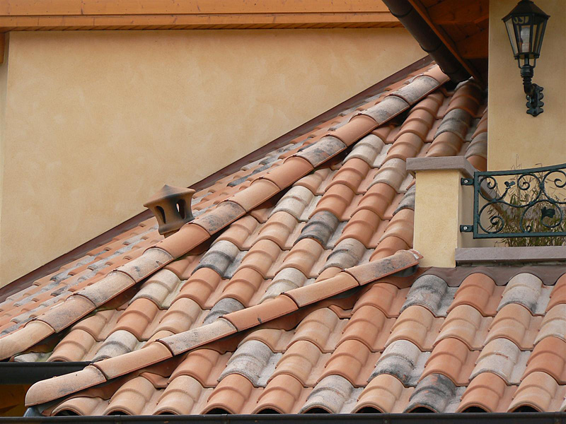 Dachówka ceramiczna ROMANE CANAL na skośnym dachu z widoczną lampą ścienną i fragmentem balustrady.