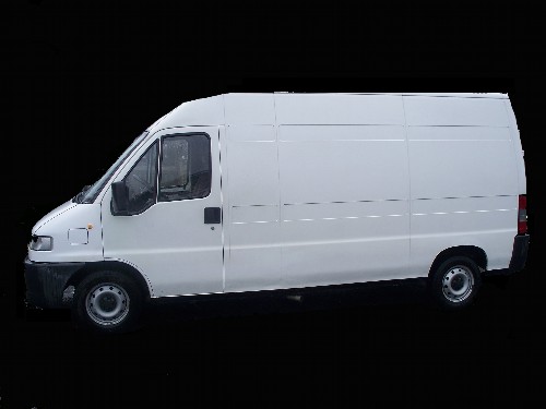 Biały furgon dostawczy z widocznymi śladami użytkowania na oponach i zderzaku, sfotografowany z boku na jednolitym czarnym tle.