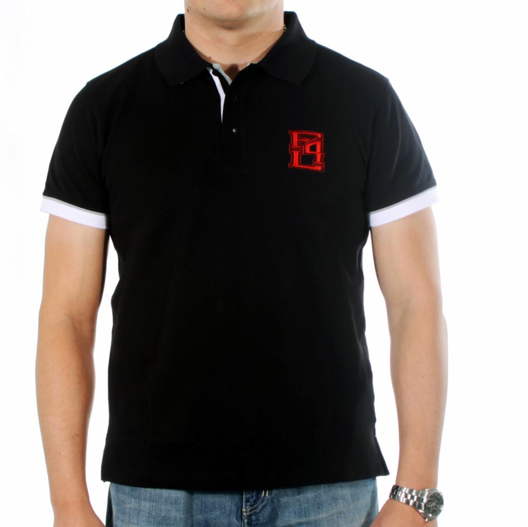 Czarna koszulka polo z krótkim rękawem i białymi mankietami, ozdobiona czerwonym, geometrycznym logo na piersi, noszona przez mężczyznę w dżinsach i z zegarkiem na nadgarstku na jasnym tle.