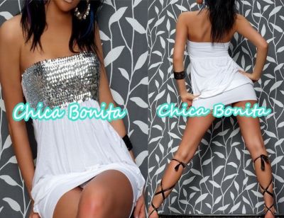 Kolaż prezentujący dwie różne perspektywy tej samej białej, bezramiączkowej sukienki mini: przód z cekinową górą i tył z detalami wiązanych sandałów na sznurowadłach, na tle szaro-białej tapety...