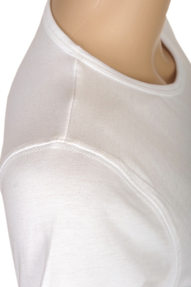 Fragment białej koszulki z okrągłym dekoltem na manekinie, widoczne detale szwów na ramieniu.