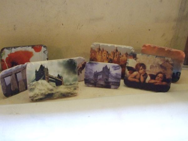 Obrazki z nadrukiem na kamiennych i drewnianych podkładkach, przedstawiające m.in. Tower Bridge podczas sztormu, Stonehenge, aniołki i kwiaty.